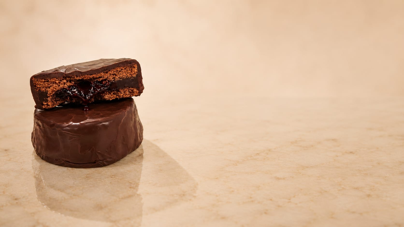Alfajor PETRA Edición Malbec cortado al medio, con relleno de vino Malbec y chocolate